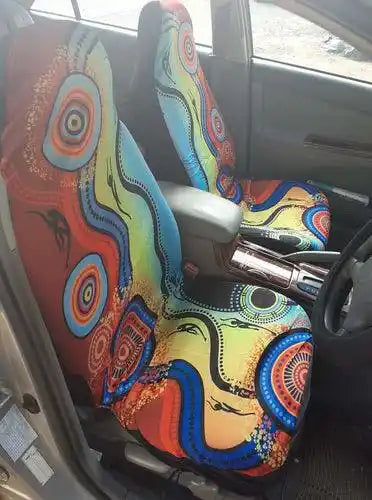 Colorful car seat covers with abstract patterns inside a vehicle.