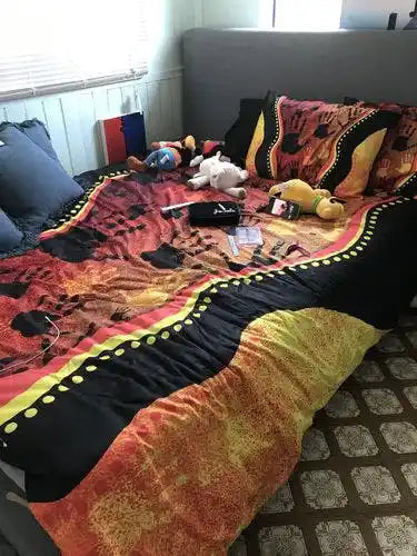 Colorful blanket with toys on a bed in a room