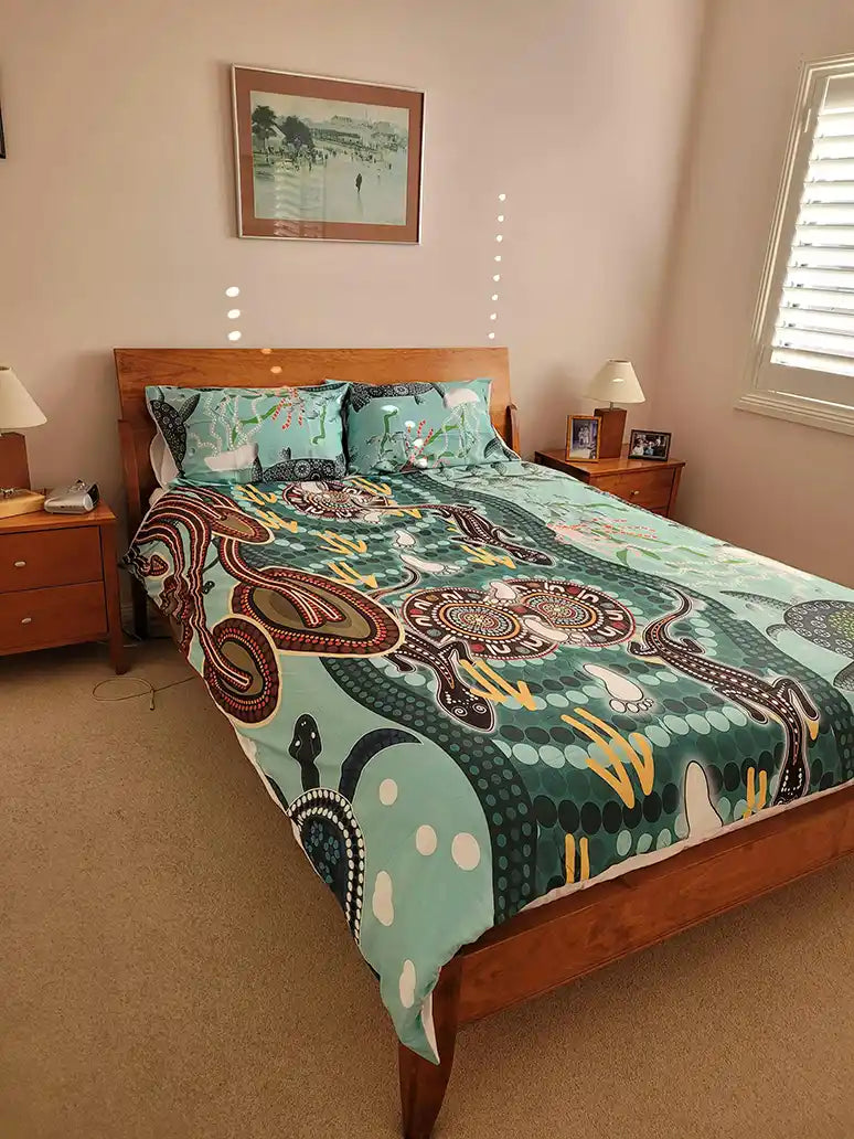 Bedroom with a bed featuring a colorful patterned comforter, wooden headboard, and nightstands.