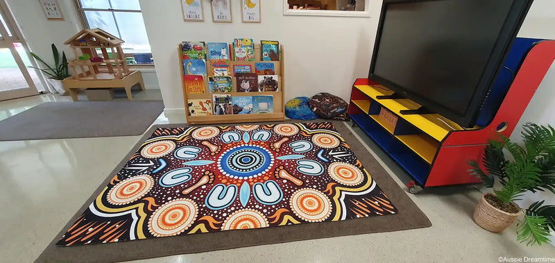 Colorful patterned rug on a gray floor with children's toys and furniture in the background.