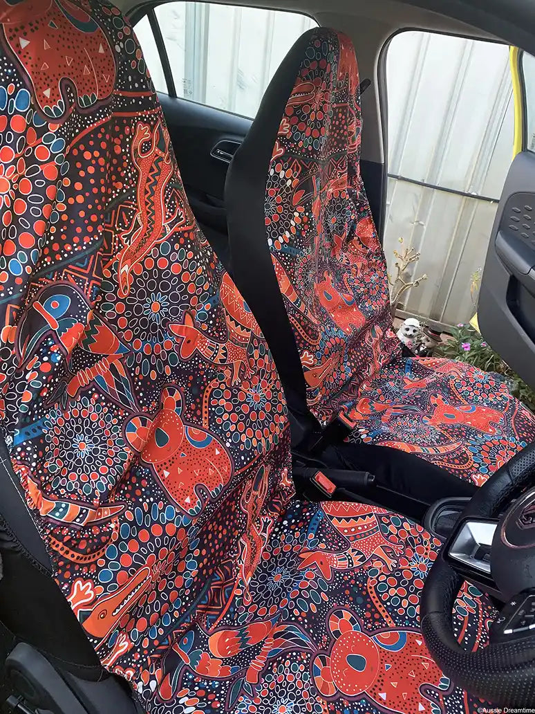 Car seat covers with a vibrant red and blue pattern inside a vehicle.