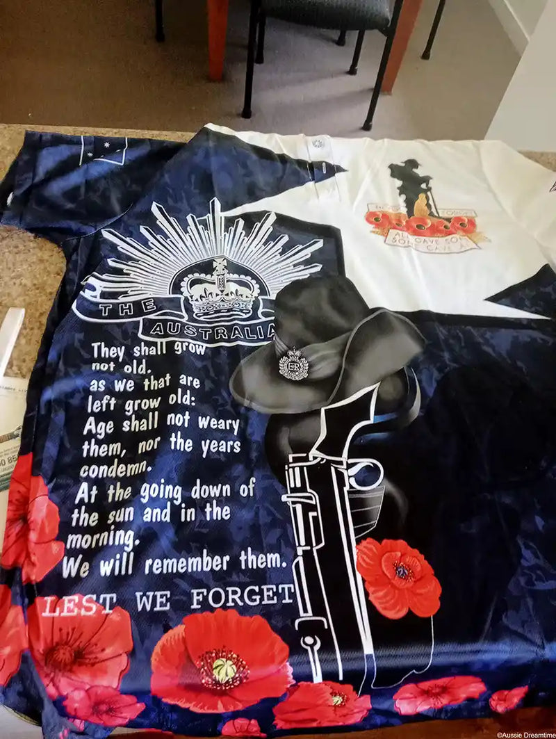 T-shirt with a design featuring a police hat, gun, and text 'Lest We Forget' on a blue background.
