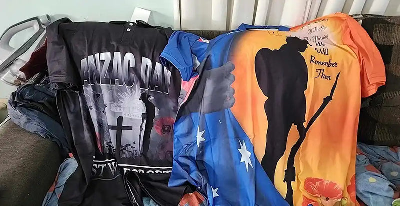 Collection of t-shirts with various designs on a couch