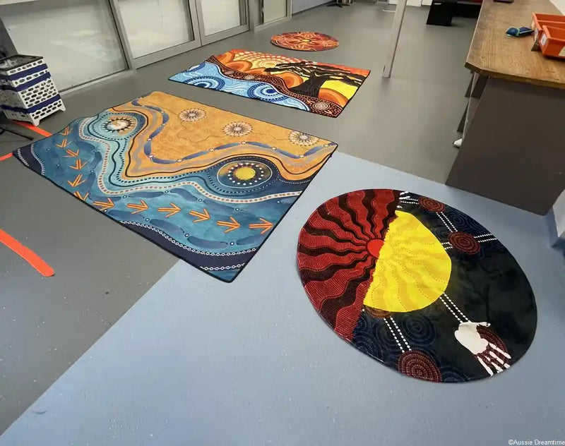 Colorful Aboriginal art rugs on a gray floor