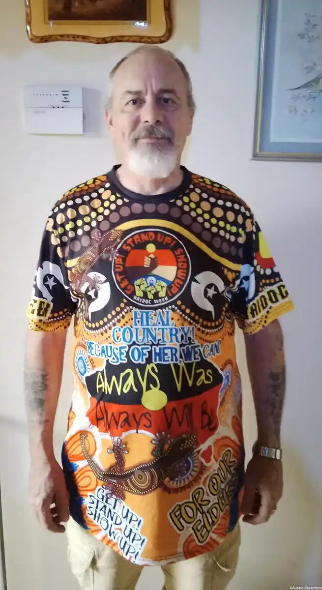 Man wearing a colorful graphic t-shirt with text and designs.
