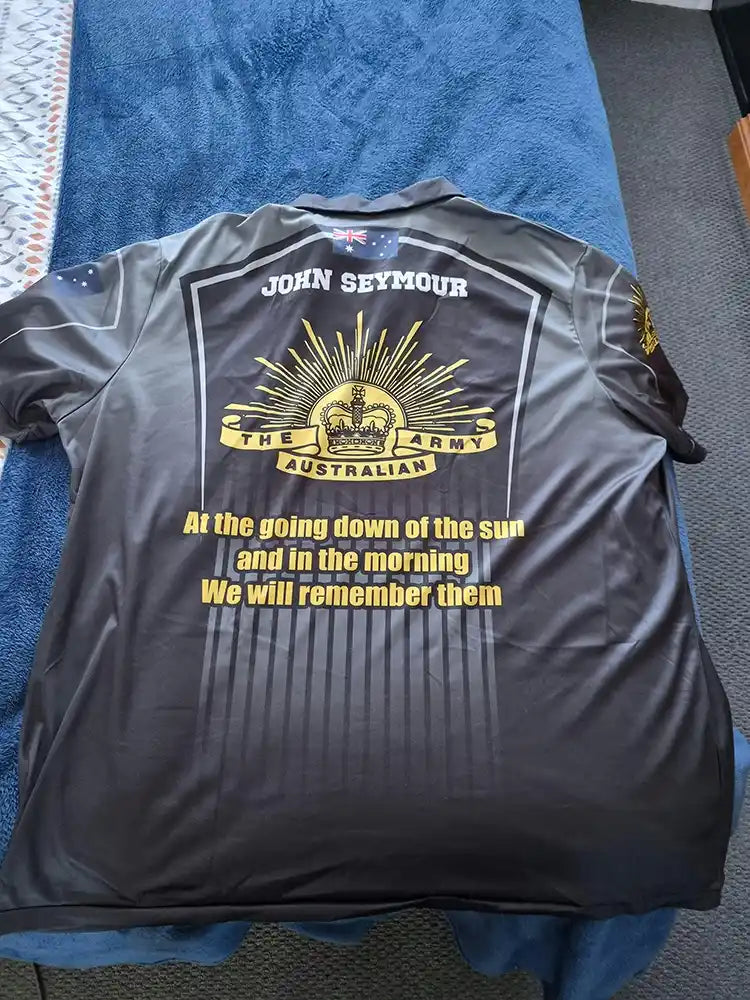 Black shirt with gold text and design on a blue surface