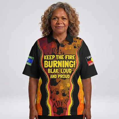 Person wearing a colorful shirt with text and designs on a white background. Australia Naidoc Week 2024 Polo Shirt - Keep The Fire Burning! Blak, Loud and Proud 4