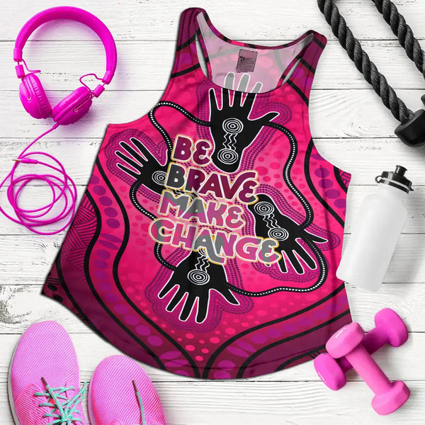 Pink tank top with motivational text, pink headphones, pink sneakers, pink dumbbells, and a black resistance band on a white wooden surface. National Reconciliation Week Women's Tank Top & Singlet - Be Brave. Make Change 1