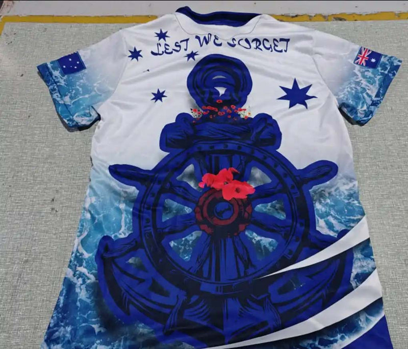 White t-shirt with blue ship's wheel design and text on a gray surface