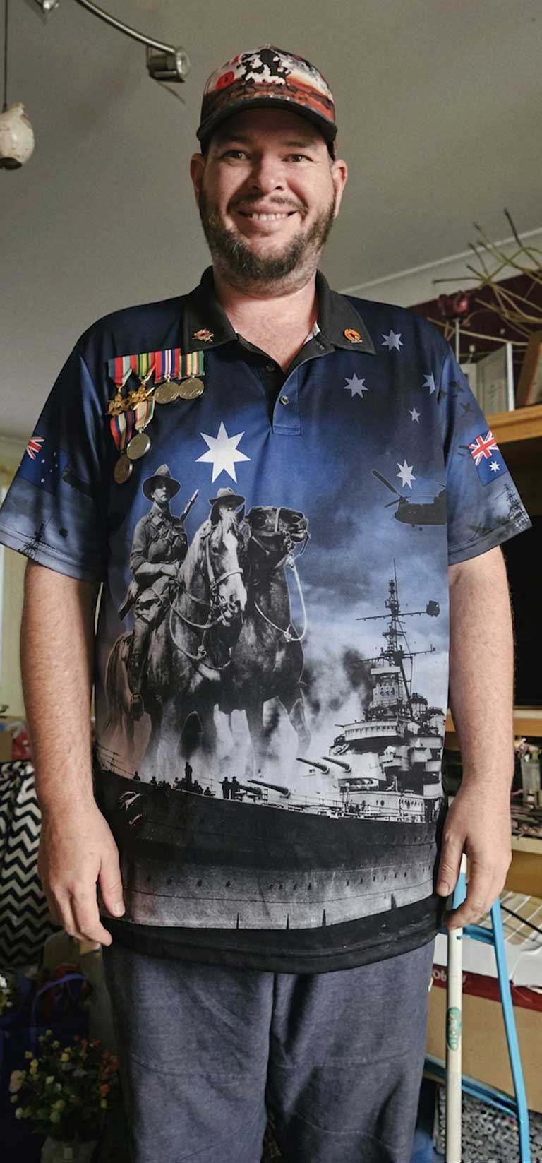 Man wearing a shirt with a military-themed design in a room.