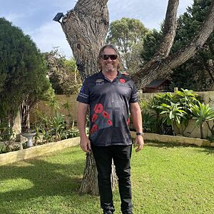 Person wearing a black t-shirt with red graphics in a garden setting