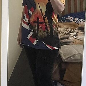 Person wearing a colorful graphic t-shirt in a bedroom setting