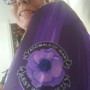 Person wearing a purple scarf with a floral design and text.