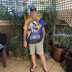 Person wearing a sports jersey with an eagle design in an indoor setting with plants.