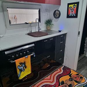 Small kitchenette with a sink, countertop, and cabinets.