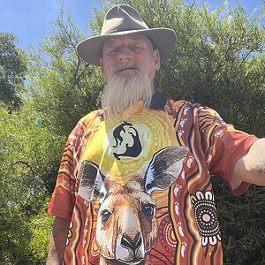 Man wearing a colorful shirt with a kangaroo design outdoors