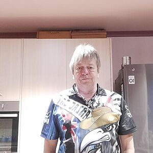 Person wearing a shirt with a guitar design in a kitchen setting