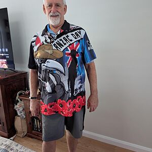 Man wearing a colorful shirt with text and graphics indoors.