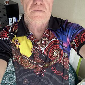 Person wearing a colorful shirt with intricate patterns and designs.