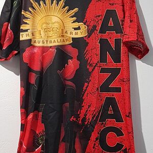 Red, black, and gold ANZAC-themed shirt with floral design on a white background