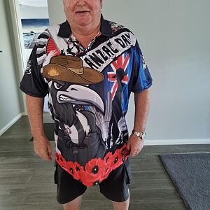 Person wearing a colorful shirt with a design and text, standing indoors.