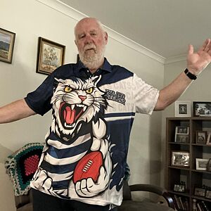 Man wearing a shirt with a cartoon tiger design in a room with furniture and decor.