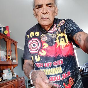 Person wearing a colorful shirt with abstract designs in a room.